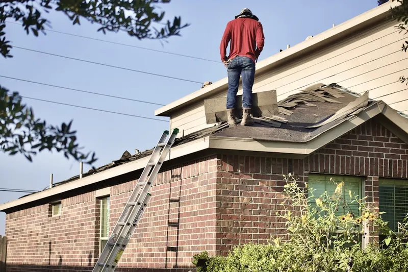 Professional roofer working on a residential roof in Amherst
